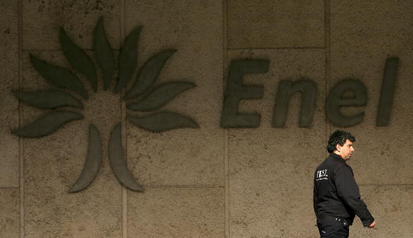 A man passes by Enel's logo at the itali